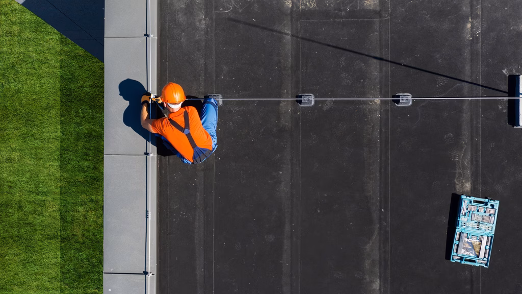 Technician Installing Lightning Protection Rod on Top of Building