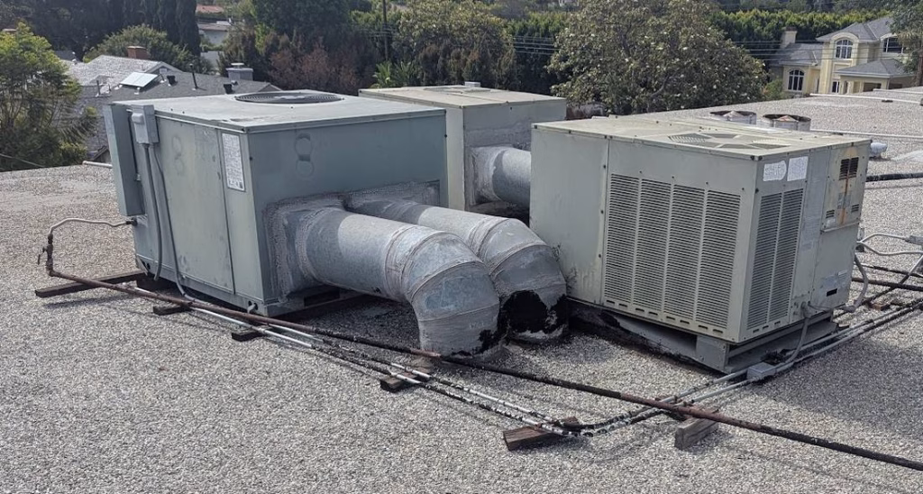 Older side-draft AC units on worn platforms before upgrade.
